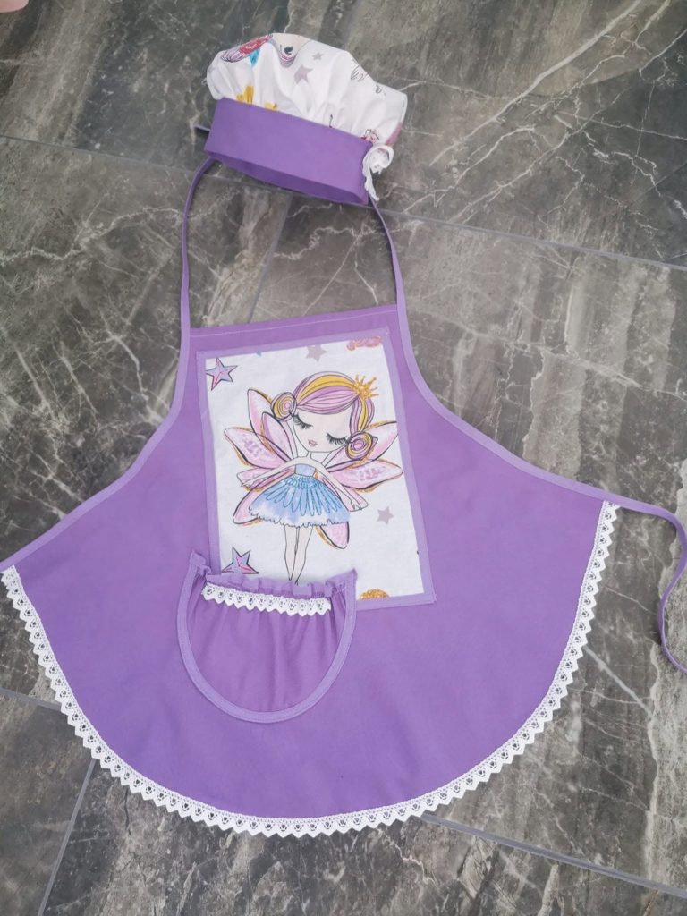 Vijoličen otroški predpasnik z motivom vile in kuharsko kapo